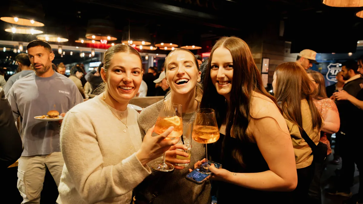Guests raising glasses at a MediaNV happy hour event